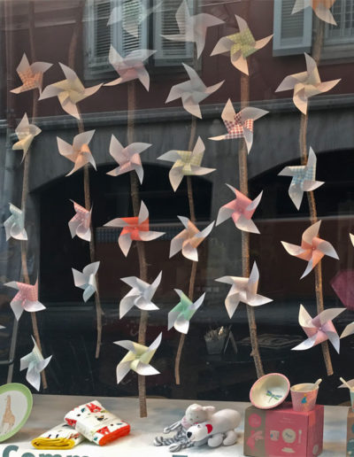 vitrine de magasin avec des petits moulins de papier