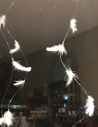 une vitrine avec de la neige représentée par des plumes blanches